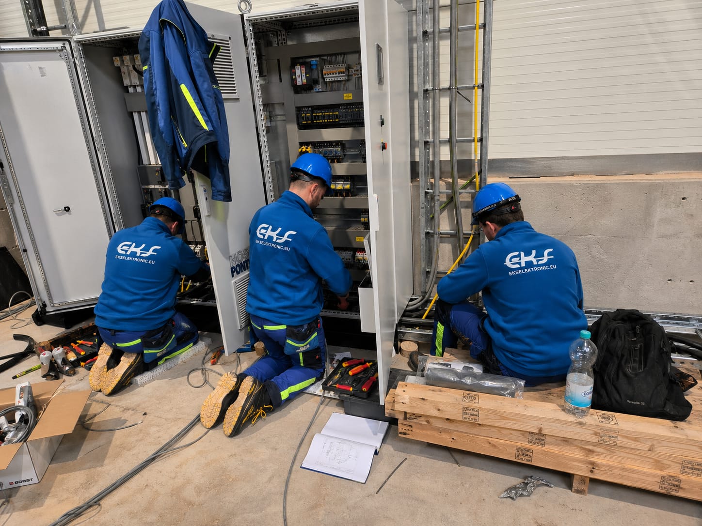 Drei Elektriker von EKS Elektronic bei Arbeiten an Schaltschränken